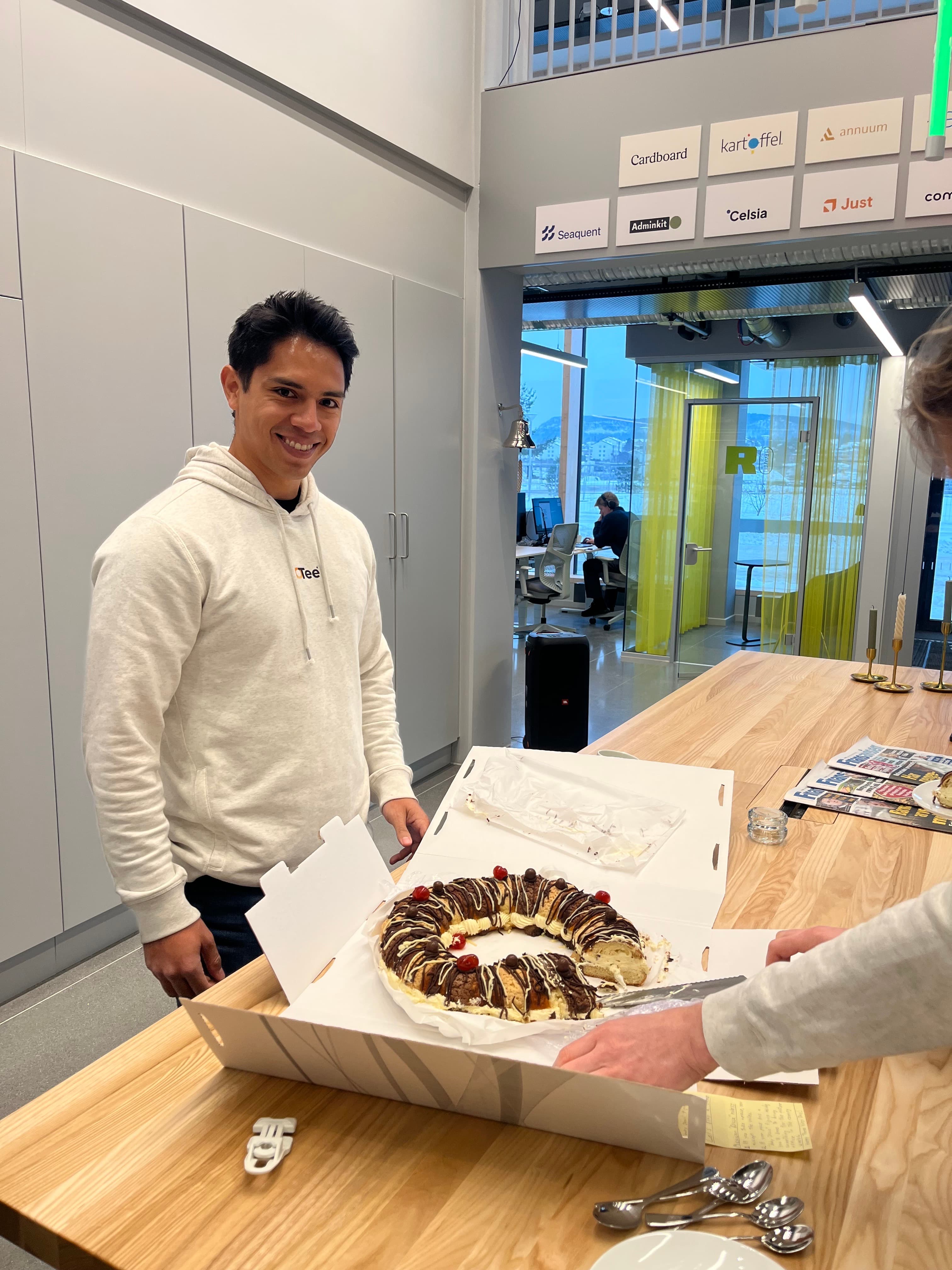 Founder with a celebration cake at the Tech Hub Industry Software Alliance wall